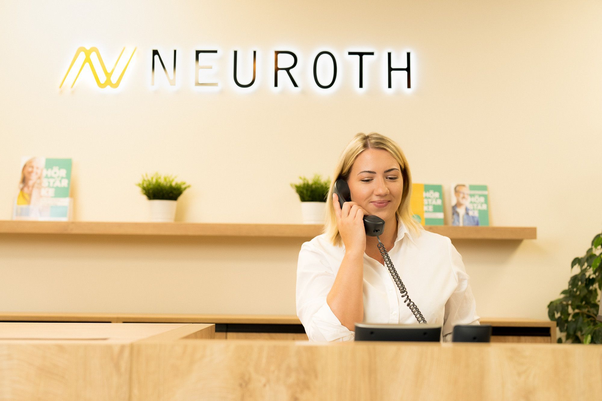 jeune audioprothesiste au telephone pupitre logo Neuroth