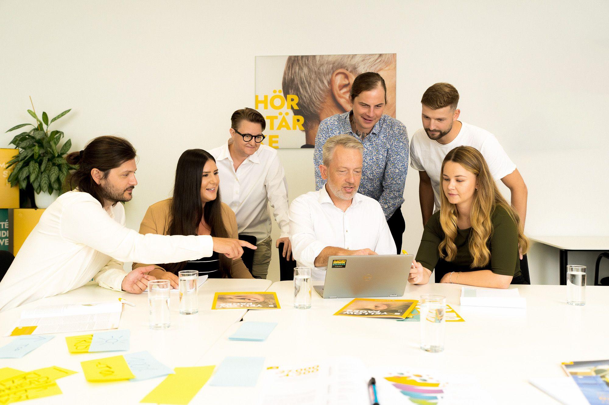Team im Headquarter Graz sitzt am Laptop und arbeitet gemeinsam Meeting